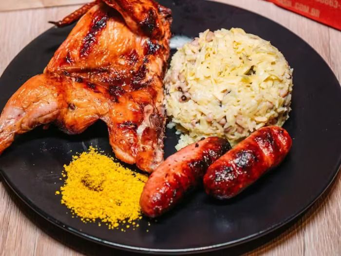 Meio galeto especial na brasa com baião de dois cremoso, linguiças e farofa crocante